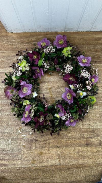 Purple Wreath - A beautiful classic wreath arranged using purple and white flowers and finished with fine foliage.