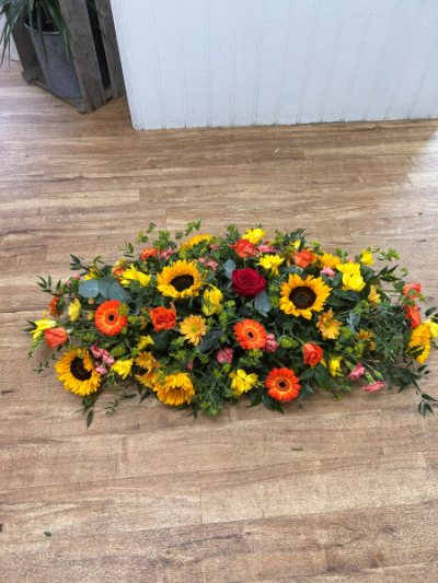 Sunshine Casket Spray - A radiant casket spray in warm, uplifting tones, lovingly handcrafted as a heartfelt final farewell.